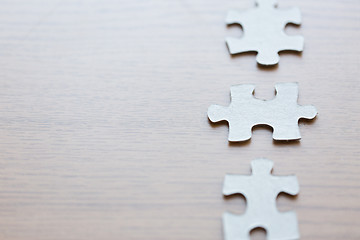 Image showing close up of puzzle pieces on wooden surface