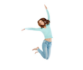 Image showing smiling young woman jumping in air