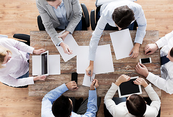 Image showing close up of business team with papers and gadgets