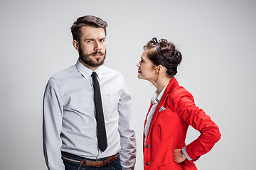 Image showing The business man and woman conflicting on a gray background