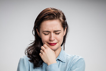 Image showing The portrait of a crying young lonely woman on gray