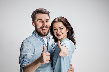 Image showing Two young smiling people with thumbs-up gesture