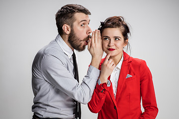 Image showing Young man telling gossips to his woman colleague at the office