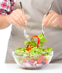 Image showing Cook is mixing salad