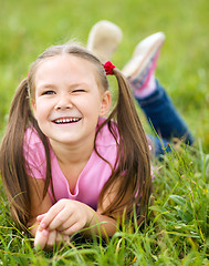 Image showing Portrait of a little girl laying on green grass