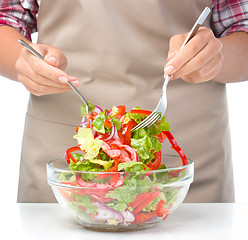 Image showing Cook is mixing salad