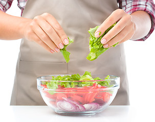 Image showing Cook is tearing lettuce while making salad