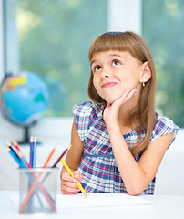 Image showing Little girl is drawing using color pencils