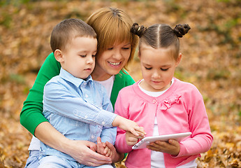 Image showing Mother is reading book with her daughter and son