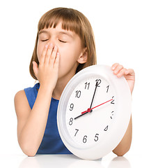 Image showing Little girl is holding big clock