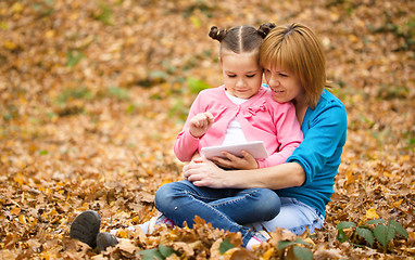 Image showing Mother is reading from tablet with her daughter