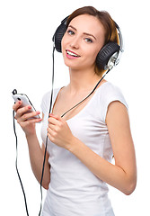 Image showing Young woman enjoying music using headphones