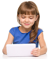 Image showing Young cheerful girl is using tablet