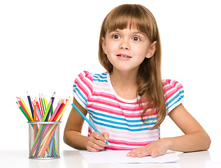 Image showing Little girl is drawing using pencils