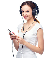 Image showing Young woman enjoying music using headphones