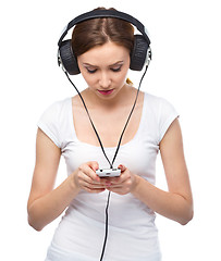 Image showing Young woman enjoying music using headphones