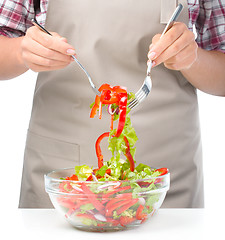 Image showing Cook is mixing salad