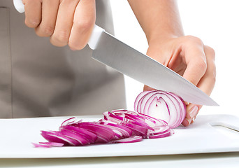 Image showing Cook is chopping onion
