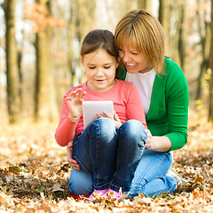 Image showing Mother and her daughter is playing with tablet