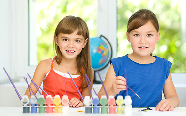 Image showing Little girls are painting with gouache