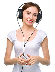 Image showing Young woman enjoying music using headphones