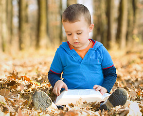 Image showing Little boy is reading book