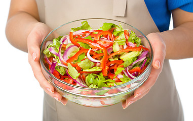 Image showing Cook is holding a big bowl with fresh salad