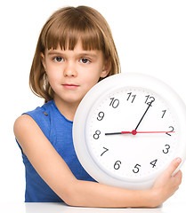 Image showing Little girl is holding big clock