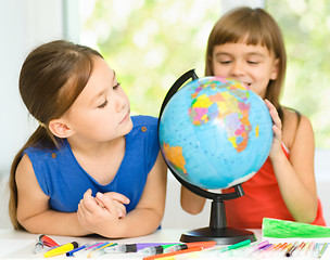 Image showing Little girls are examining globe