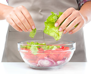 Image showing Cook is tearing lettuce while making salad