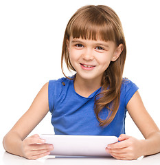 Image showing Young cheerful girl is using tablet