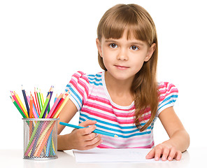 Image showing Little girl is drawing using pencils