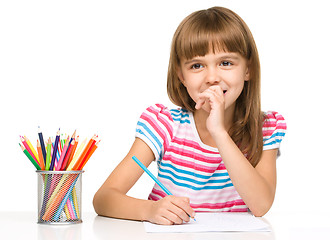 Image showing Little girl is drawing using pencils