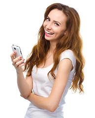 Image showing Young woman is pleased by incoming message