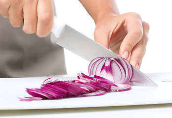 Image showing Cook is chopping onion