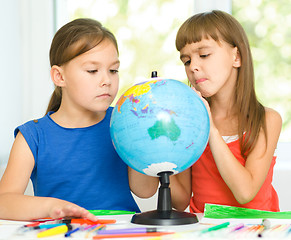 Image showing Little girls are examining globe