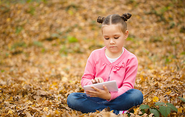 Image showing Little girl is reading from tablet