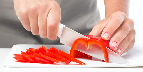 Image showing Cook is chopping bell pepper