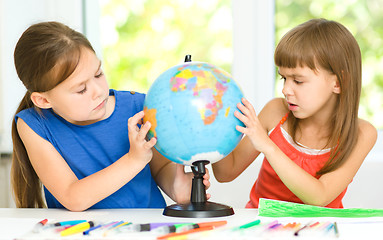 Image showing Little girls are examining globe