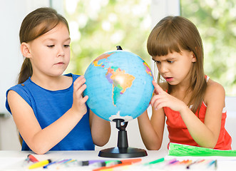 Image showing Little girls are examining globe