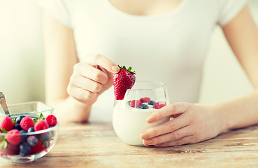 Image showing close up of woman hands with yogurt and berries