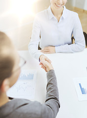 Image showing two smiling businesswoman shaking hands in office