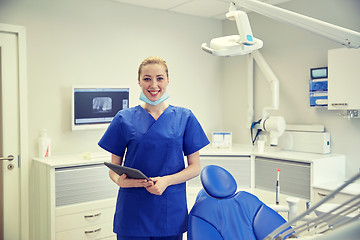 Image showing happy female dentist with tablet pc at clinic
