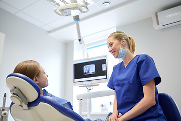 Image showing happy female dentist with patient girl at clinic