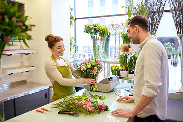 Image showing smiling florist woman and man at flower shop