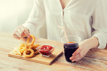 Image showing close up of woman with snacks and cola