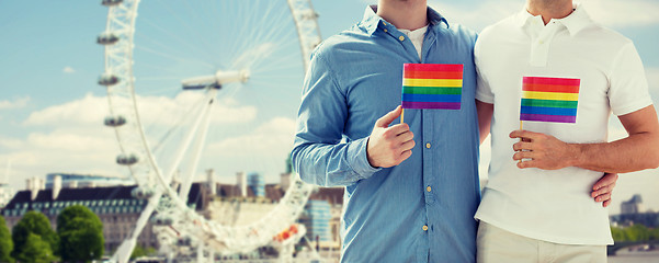 Image showing close up of male gay couple with rainbow flags