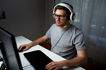 Image showing man in headset playing computer video game at home