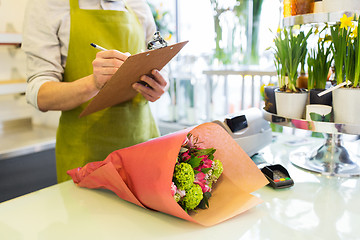 Image showing close up of man with clipboard at flower shop