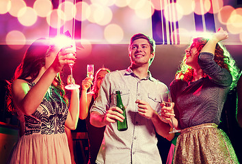 Image showing smiling friends with wine glasses and beer in club